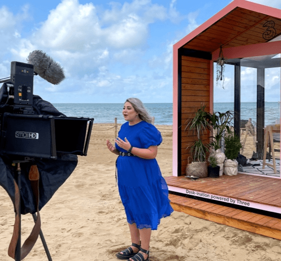 Three Live presenter Allie being filmed on a beach